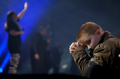 Young boy Prays during Worship concert